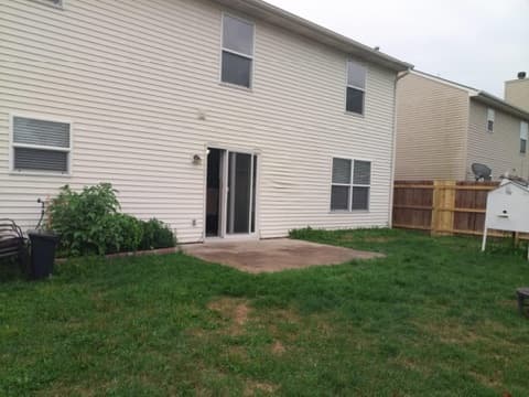 Before the project: a small rectangular slab outside the back door, surrounded by lawn.